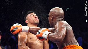 Floyd Mayweather Jr. delivers a right to Victor Ortiz in the fourth round of their fight on Saturday.