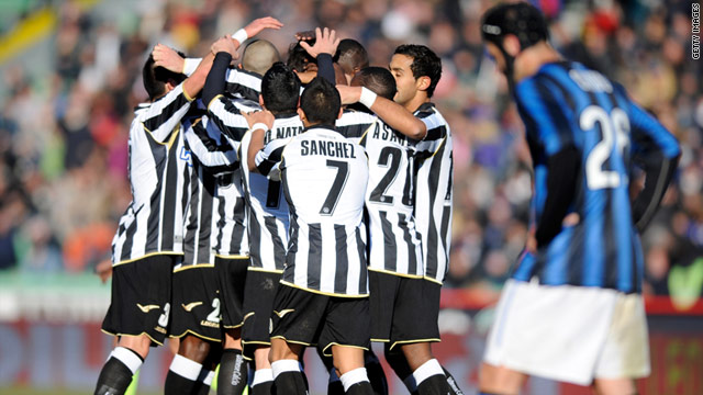 A dejected Cristian Chivu walks past a huddle of Udinese players celebrating their third goal in a 3-1 win over Inter in Serie A.