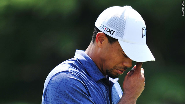 A dejected Tiger Woods contemplates missing the cut for only the third time in a major tournament.