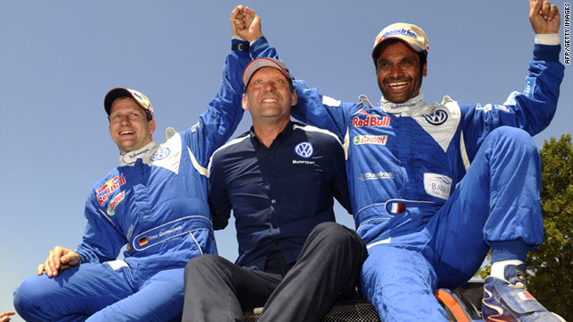 Nasser Al-Attiyah, right, celebrates with co-driver Timo Gottschalk, left, and team manager Chris Niessen.