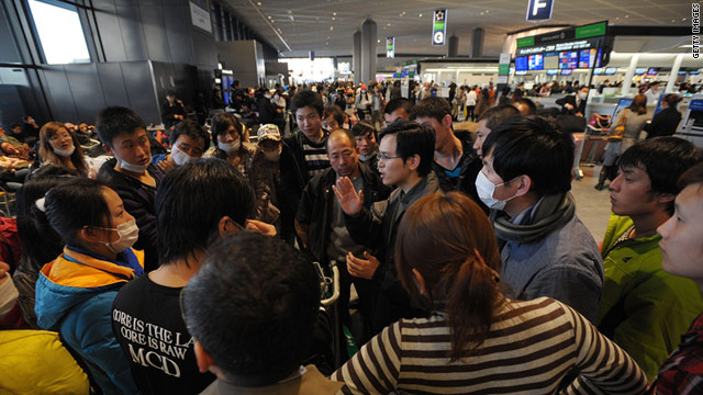 Tourists from China listen to their tour leader Friday at Narita International Airport outside Tokyo, Japan.