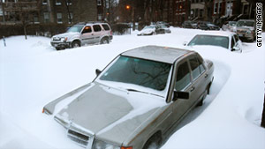 Cars are buried in snow on Wednesday in the Bucktown neighborhood of Chicago.