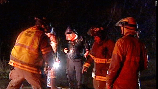 Rescue workers plot their strategy Thursday night in the search for four children who were swept away by a creek.