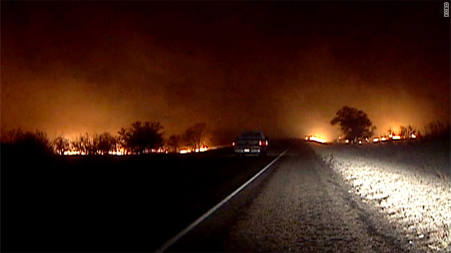 A pickup drives through a fire line Sunday in Matador, Texas, northeast of Lubbock.