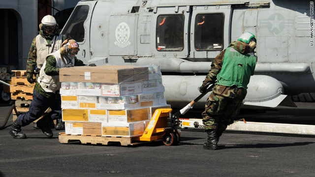 Sailors move food and other supplies across the USS Ronald Reagan's flight deck for earthquake and tsunami victims in Japan.