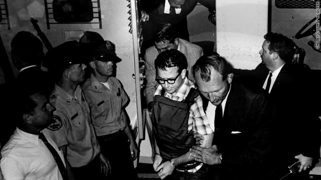 Police escort a handcuffed James Earl Ray after his extradition to Tennessee from England, where he'd been captured.