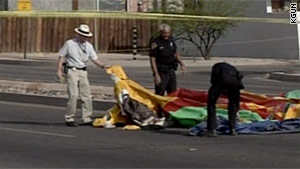 Investigators examine the deflated castle in the median on Speedway Boulevard on Saturday.
