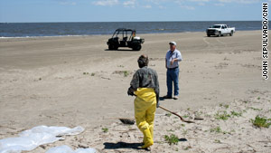 SEACOR's Jim McHale, background, manages oil cleanup workers on Elmer's Island, Louisiana.