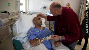 Marinovich visits Silva in the hospital where he is recovering after stepping on a land mine in Afghanistan in October.