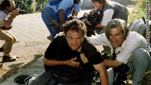 Greg Marinovich, center, was shot and wounded in this 1994 gun battle in a South Africa township.  Colleague Ken Oosterbroek, in the background, did not survive.