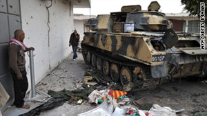 Libyans in the besieged city of Misrata walk past a tank that belong to the forces of Col. Moammar Gadhafi. The U.S. and its allies have imposed a no-fly zone over Libya.