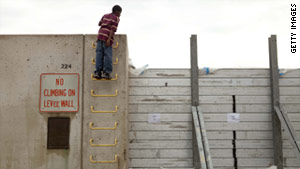 A boy in Cairo, Illinois, looks over a levee wall holding back floodwaters from the Ohio River.