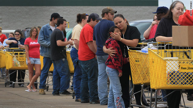 Blanca Lopez holds her daughter, Bianca, as they wait in line with other storm victims to get donated items in Joplin on Thursday.