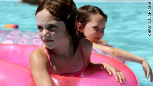 Children in Minneapolis escape the high temperatures by swimming in a public pool at a park.