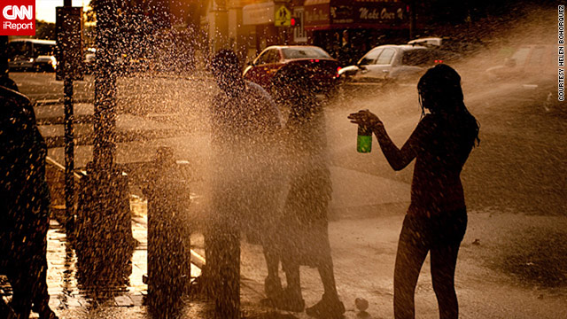 Residents cool off in the fire hydrant water in Queens, New York, to escape the unusually hot weather.