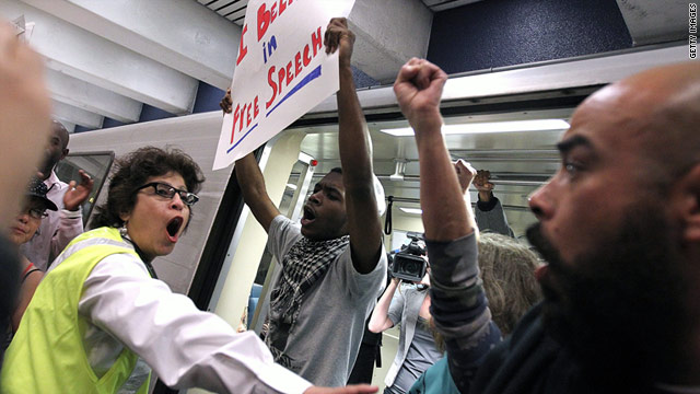 A BART worker tries to prevent demonstrators from stopping a train from leaving in San Francisco, California.
