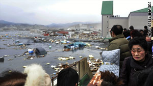 Japanese residents survey the damage after the March 11 tsunami, which was detected by radar.