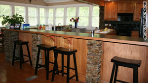 The kitchen, with its sleek countertops and black saddle stools, could be on the cover of a magazine.