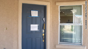 A notice on the door of a North Las Vegas home says it's vacant. The windows have been broken out.