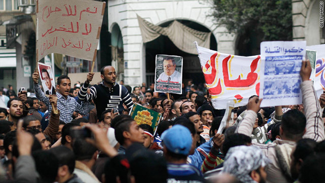 Government backers, left, holds signs in front of anti-government protesters, foreground, at Cairo's Talaat Harb Square.