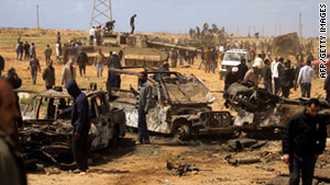 Libyans gather March 21 at a site near Benghazi where Gadhafi's forces were targeted by a French air strike.