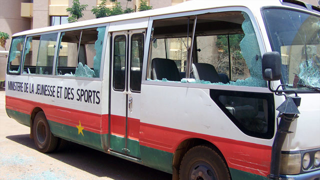 A bus sits on a street in Burkina Faso with its windows smashed due to the unrest.