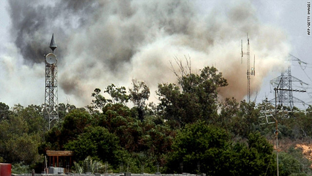 Smoke billows behind the trees following an air raid on Tajura, about 30 kilometers (18.6 miles) east of Tripoli on Tuesday.