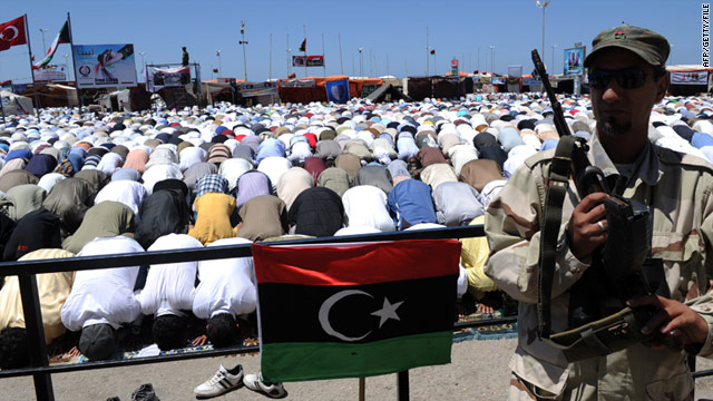 A Libyan rebel stands guard as Muslims perform a mass Friday noon prayer in the rebel stronghold of Benghazi on May 20.