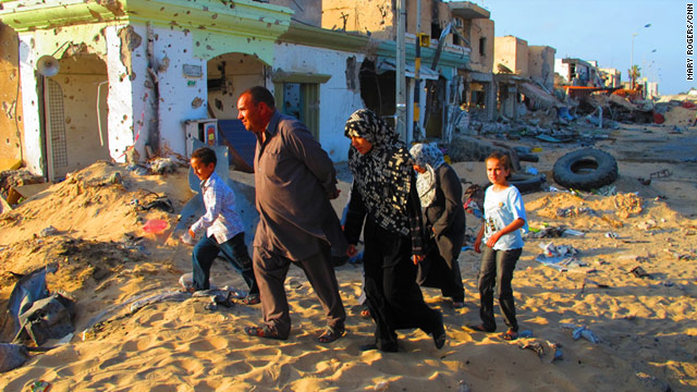 A family walks through the rubble of Misrata on Thursday. Now that the siege is over, people feel safe enough to come out.