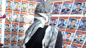 A man at a shop in Misrata, Libya, looks at photos of those killed in fighting.