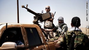 Libyan rebels arrive in the area of Ajdabiya, Libya, on Thursday, having returned from al-Brega.