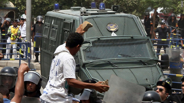 Egyptian protesters throw stones at a police convoy carrying ex-interior minister Habib El Adly outside a court in Cairo.