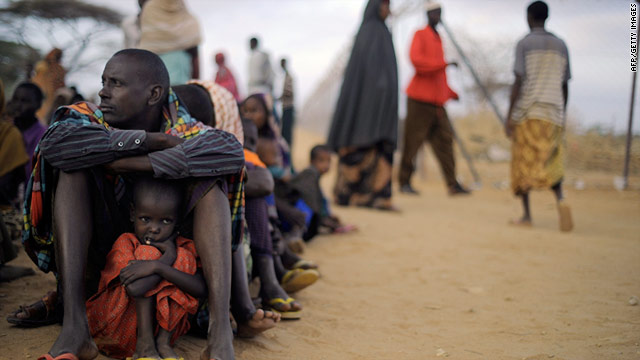 A Somali father and daughter sit at the head of a queue at a registration center at the Dagahaley refugee site.