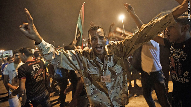 A Libyan rebel fighter in Benghazi celebrates the news one of Moammar Gadhafi's sons has been captured in Tripoli.