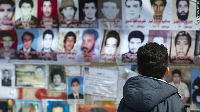 A child looks at photos of some of the 1,200 prisoners killed at Abu Salim in the summer of 1996.