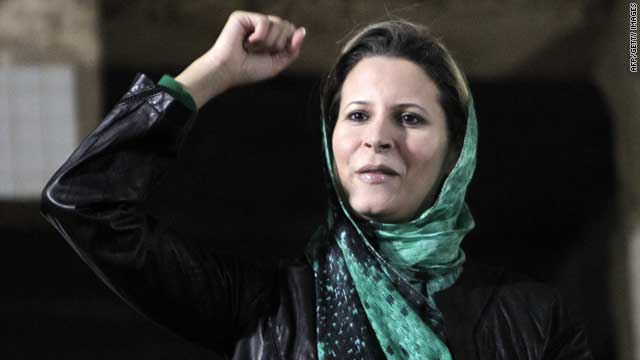 Aisha, daughter of Moammar Gadhafi, salutes the crowds gathered in her father's residence in Tripoli on April 15, 2011.