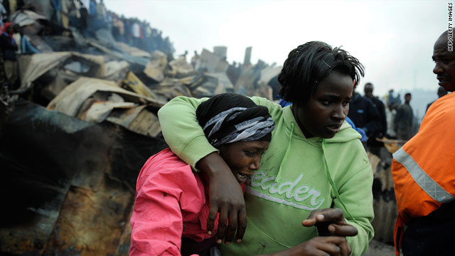 A woman is comforted after seeing the body of her child on at the scene of a fire in a slum area in Nairobi.