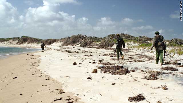 Armed policemen patrol a stretch of beach near Kiwayu Safari village, Kenya, on September 12, 2011.
