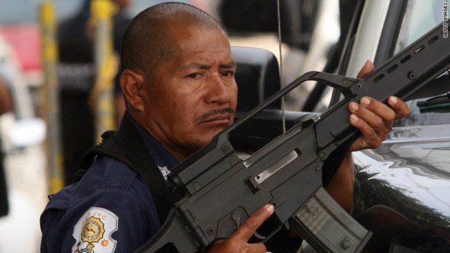 A police officer takes position during a confrontation with members of a gang in Acapulco, Mexico, on January 8.
