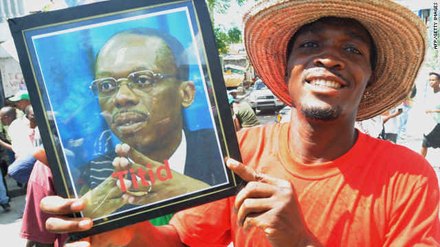 A supporter of former Haitian President Jean-Bertrand Aristide holds a sign last month at a rally calling for Aristide's return.