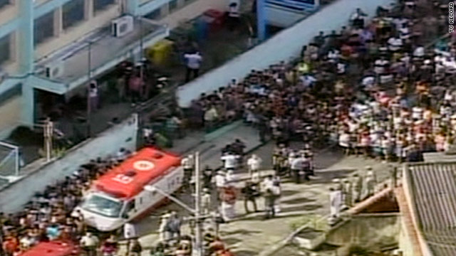 People stand outside a school in Rio de Janeiro where children and adults were reportedly shot to death on Thursday.