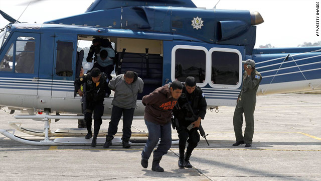 Three alleged members of Mexican drug cartel Los Zetas are escorted by members of the National civil Police upon arrival at the Guatemalan Air Force base in Guatemala City on May 21.