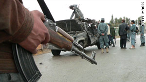 Afghan police inspect the wreckage of the deputy governor's car Saturday after an attack by a suicide bomber in Kandahar.