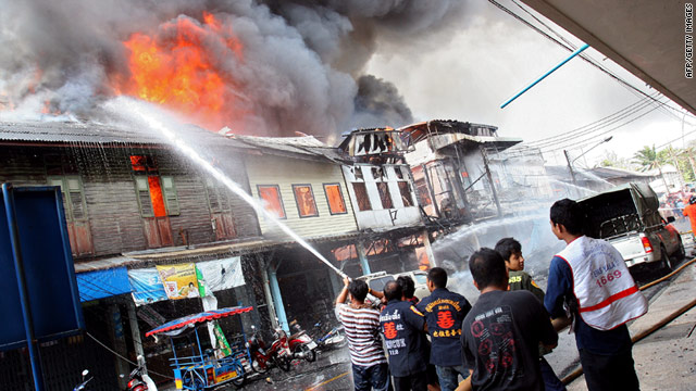 Thai firemen try to extinguish a fire at the site of the bomb blast in Yala.