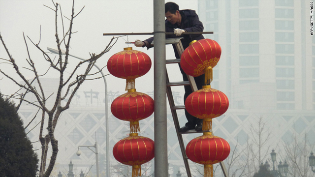 Workers remove red lantern decorations for the just completed lunar festivities amid stifling smog in Beijing Wednesday.