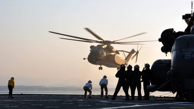 Helicopters land on the USS Tortuga in the Sea of Japan on Saturday as the U.S. military prepares to deliver aid.