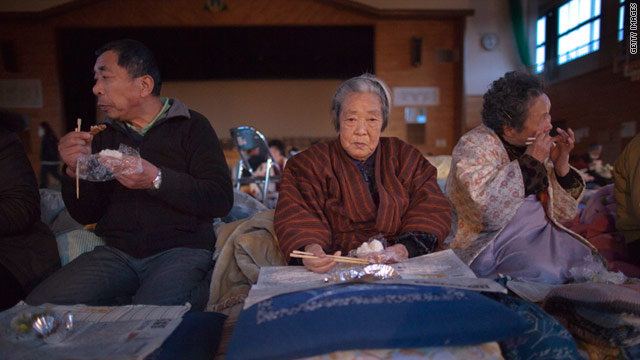 Japanese families eat dinner at a shelter on March 16, 2011 in Kesennuma, located in the northeast of Miyagi prefecture.