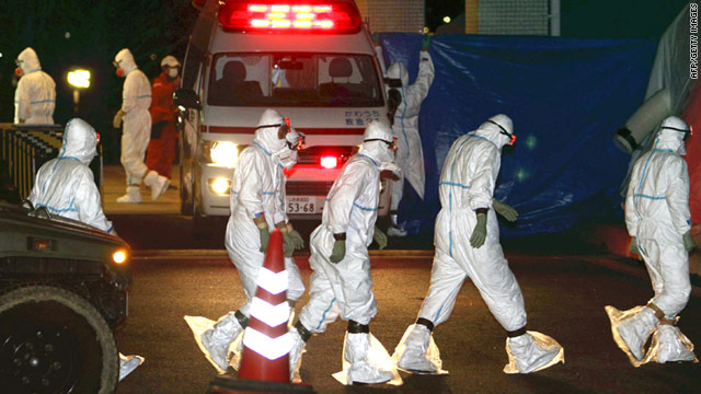 Workers in protective suits prepare Thursday to decontaminate two nuclear plant workers in Fukushima, Japan.