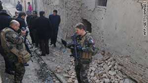 Soldiers with the NATO-led ISAF and Afghan policemen investigate at the site of an explosion in Kabul in January.