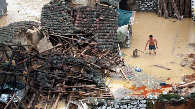 A man tries to salvage some belongings from his damaged home Thursday as floods hit Laibin, southwest China.